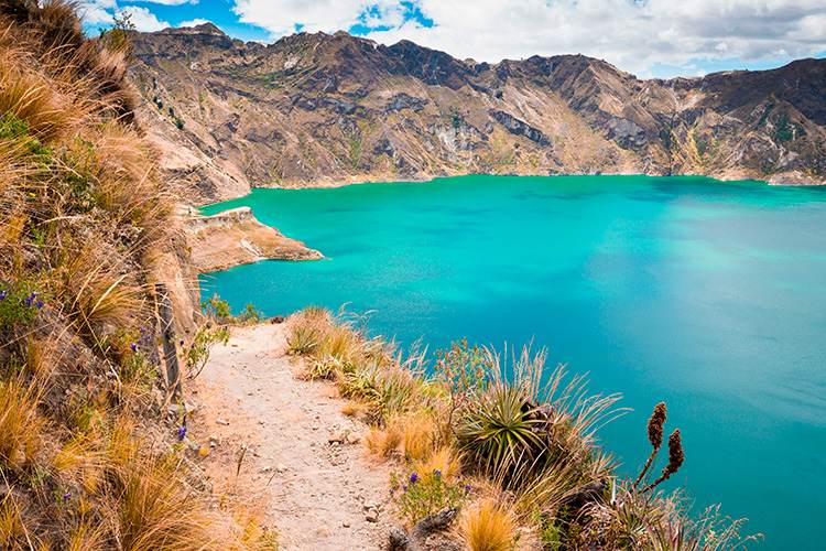 Un sendero que conduce a un lago azul en las montañas.