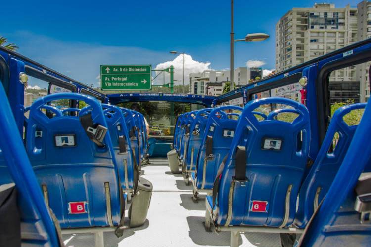 El interior de un autobús con asientos azules.