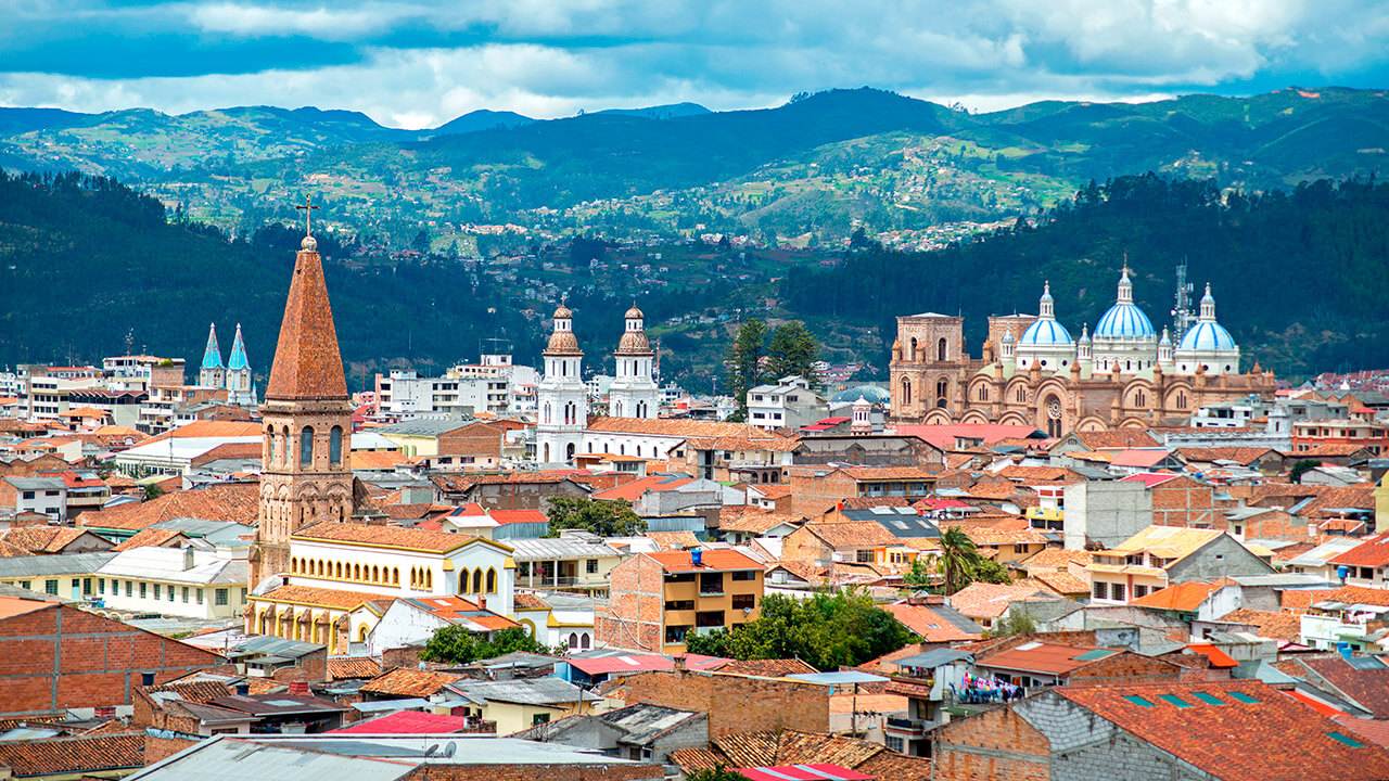 Una ciudad de colombia con una iglesia y montañas al fondo.