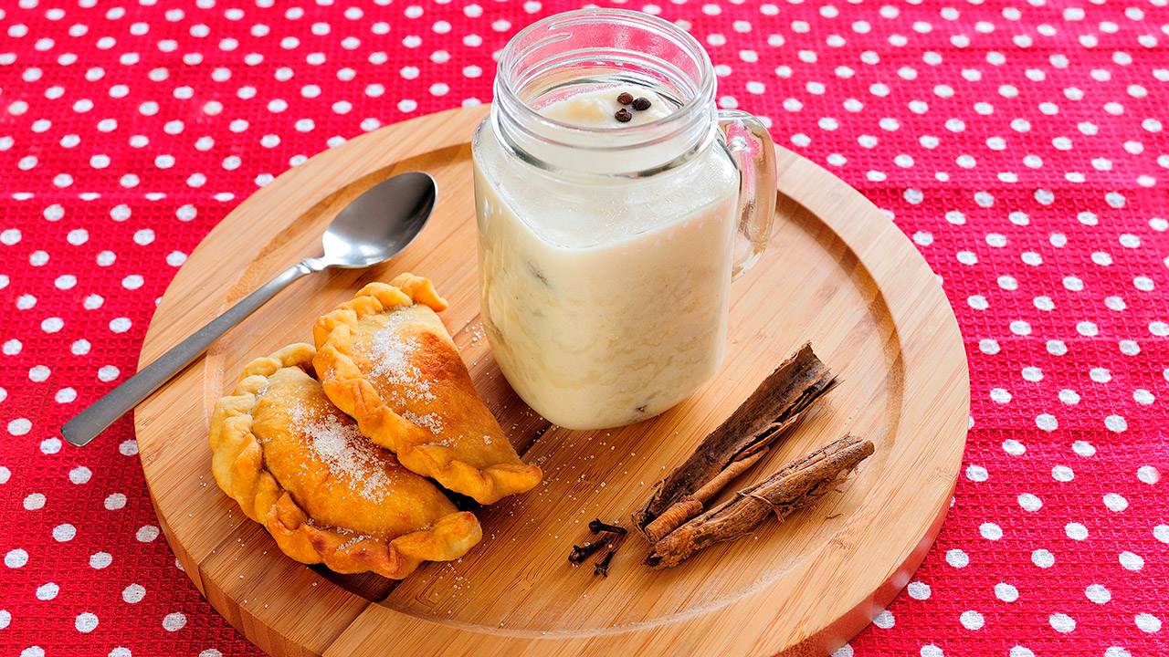 Un plato con dos pasteles y una taza de leche.