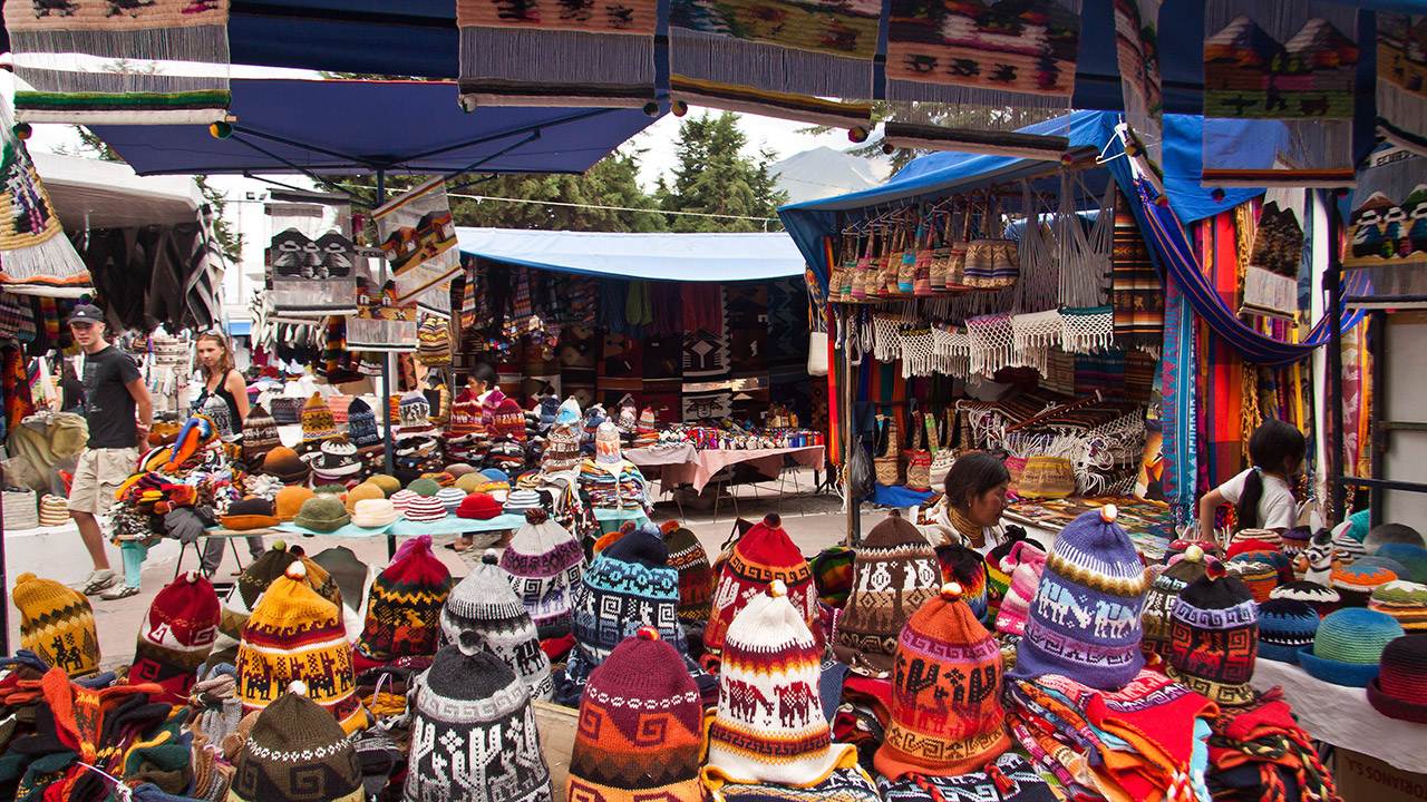 Un mercado con muchos sombreros y bufandas de colores.