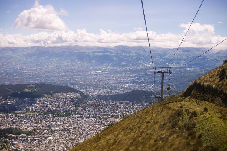 Un teleférico en una montaña con vistas a una ciudad.