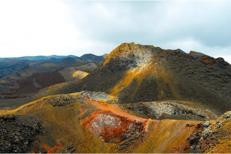 Una vista de una montaña cubierta de arena naranja y amarilla.
